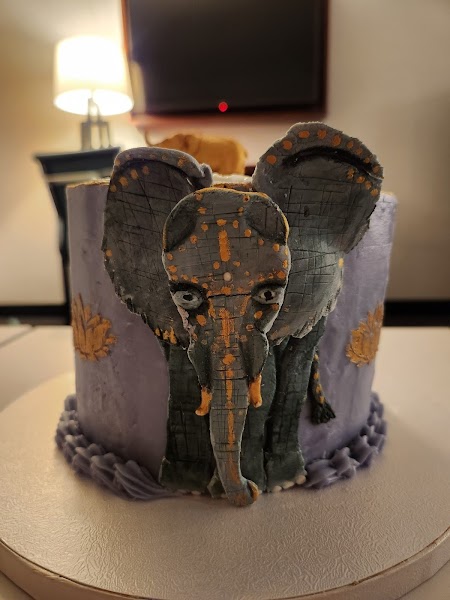 Elegant elephant-themed cake in lavender and gray with gold lotus flower accents