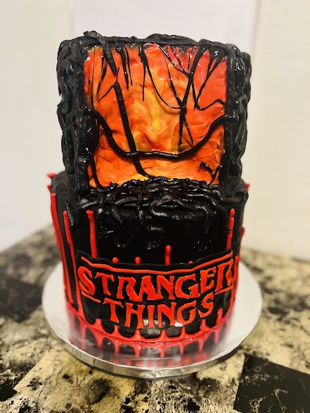 Two-tier Stranger Things themed cake with red portal scene and Upside Down design