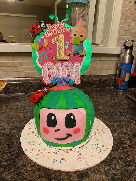 CoComelon themed first birthday cake shaped like a watermelon character for Gigi